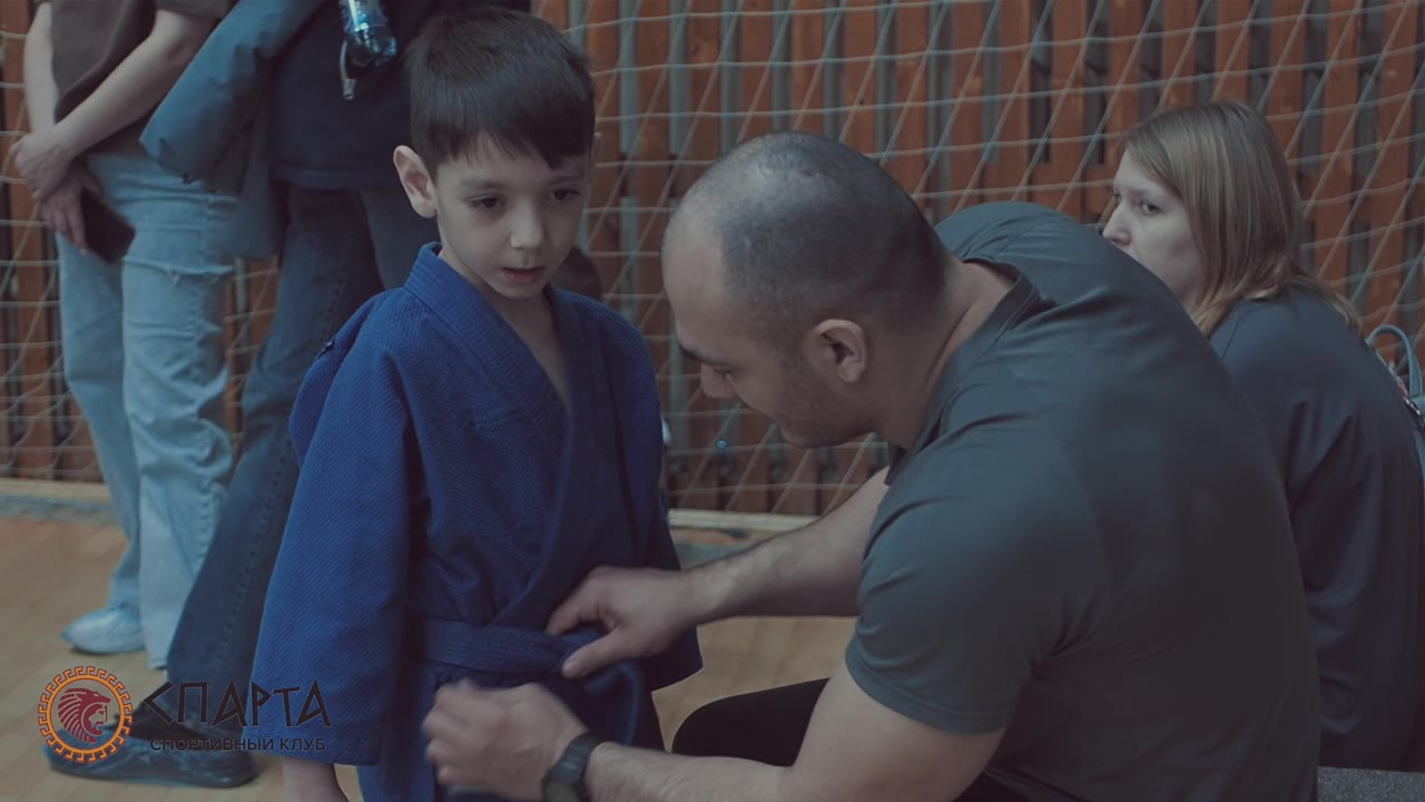 Тренер завязывает пояс